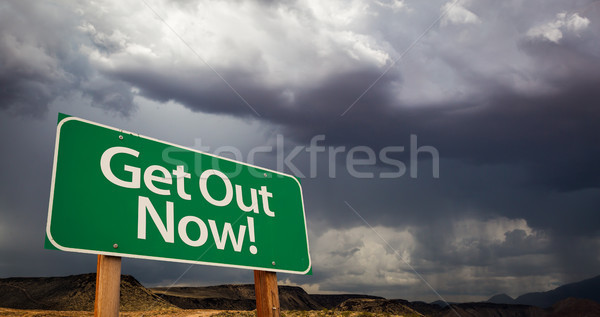 Stock photo: Get Out Green Road Sign and Stormy Clouds