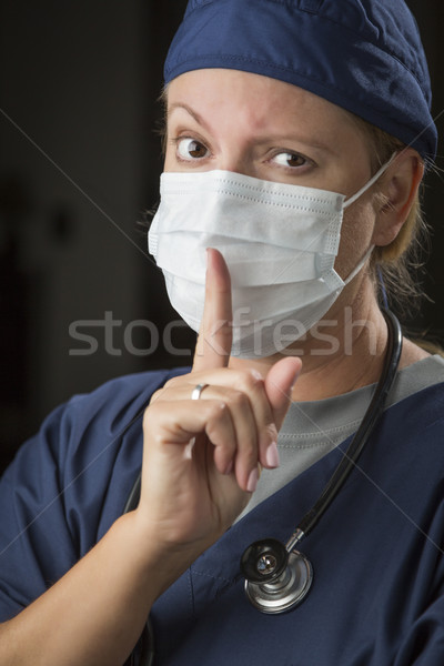 Secretive Female Doctor with Finger in Front of Mouth Stock photo © feverpitch