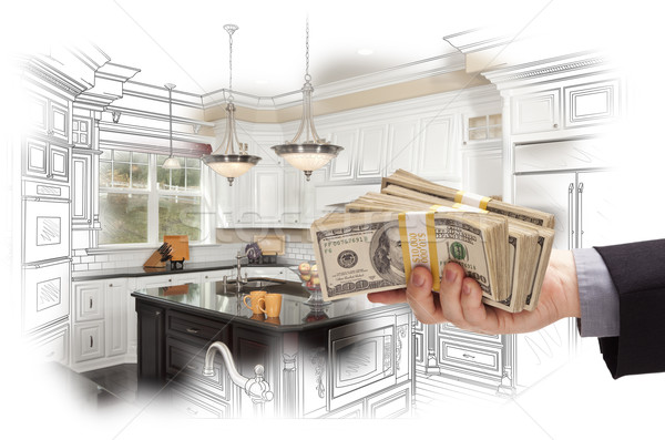 Hand Holding Cash Over Kitchen Design Drawing and Photo Combinat Stock photo © feverpitch