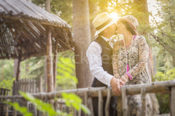 Stock photo: 1920s Dressed Romantic Couple Kissing on Wooden Bridge