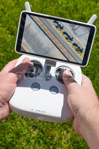Stock photo: Hands Holding Drone Quadcopter Controller With Overhead of Tract