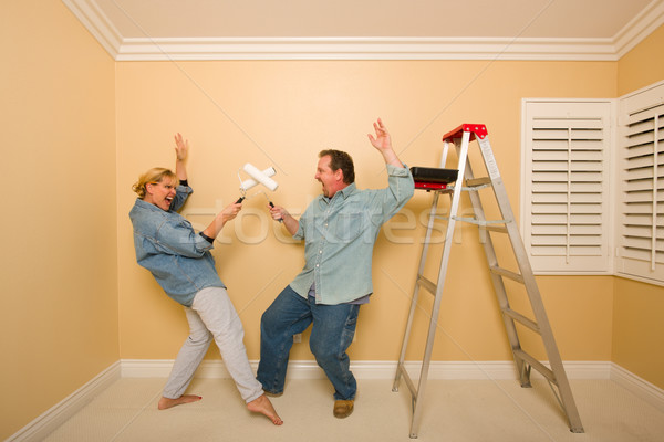 Fun Couple Playing Sword Fight with Paint Rollers Stock photo © feverpitch
