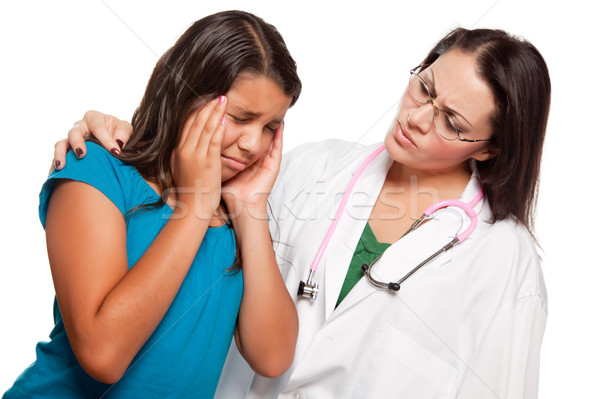 Unhappy Hispanic Girl and Concerned Female Doctor Stock photo © feverpitch