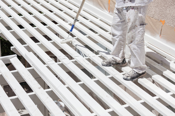 Stock photo: Professional Painter Rolling White Paint Onto The Top of A Home 