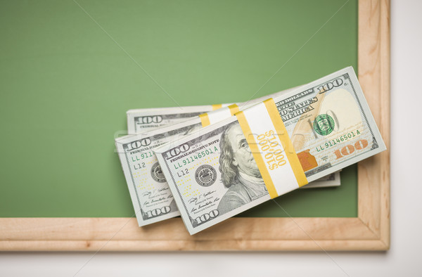 Newly Designed One Hundred Dollar Bills Stacked on Chalk Board Stock photo © feverpitch