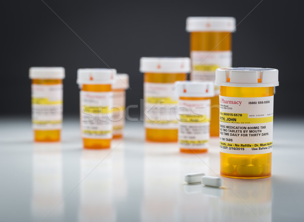 Medicine Bottles and Pills on Reflective Surface With Grey Backg Stock photo © feverpitch