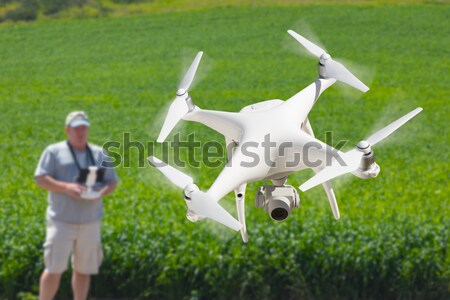 Drone Quadcopter (UAV) In Air Above Pilot With Remote Controller Stock photo © feverpitch