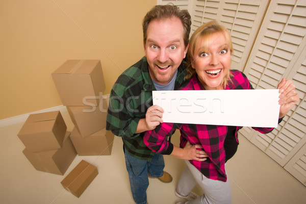 Stock photo: Happy Couple Holding Blank Sign in Room with Packed Boxes