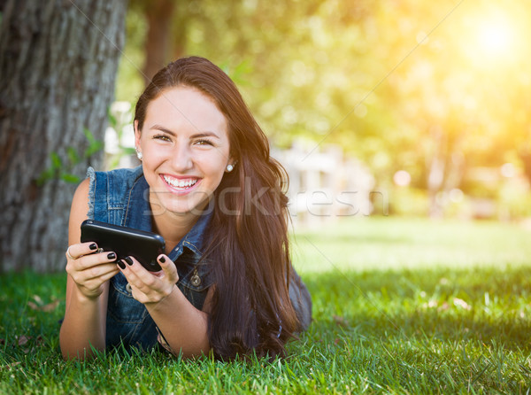 Mixed Race Young Female Texting on Cell Phone Outside In The Gra Stock photo © feverpitch