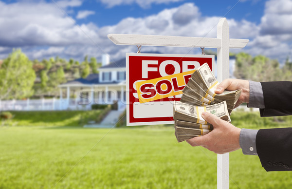 Man Handing Over Money in Front Sold House and Sign Stock photo © feverpitch