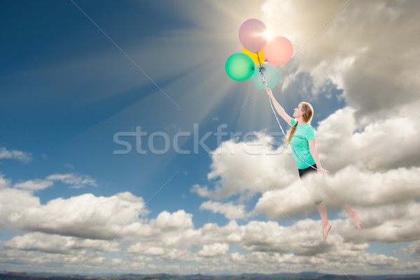 Young Adult Female Being Carried Up and Away Into The Clouds By  Stock photo © feverpitch