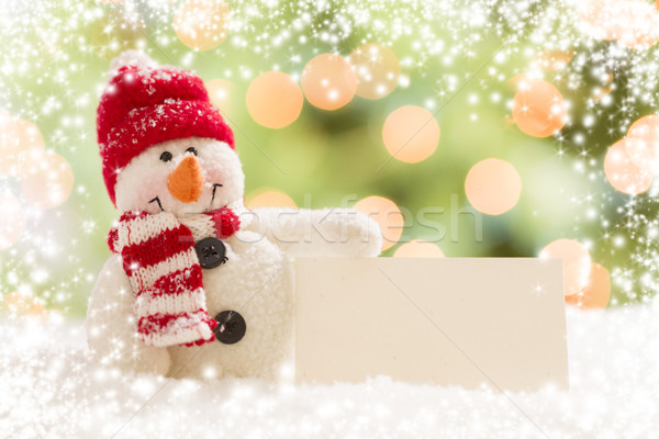 Stock photo: Snowman with Blank White Card Over Abstract Snow and LIght