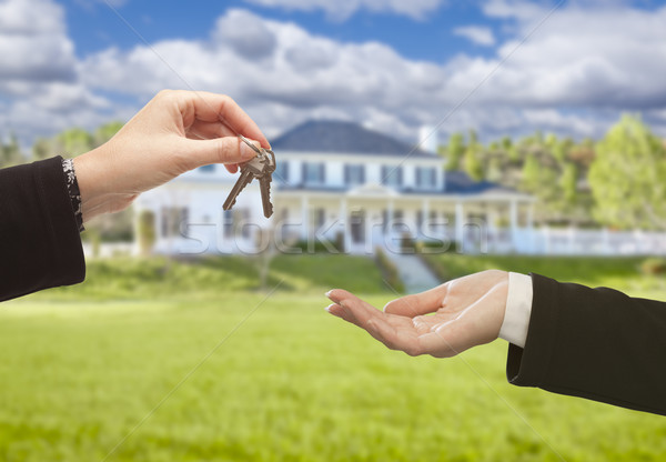 Agent Handing Over House Keys in Front of New Home Stock photo © feverpitch