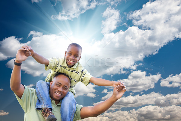 Happy African American Man with Child Over Clouds and Sky Stock photo © feverpitch