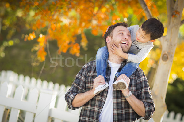 Mixed Race Boy Riding Piggyback on Shoulders of Caucasian Father Stock photo © feverpitch