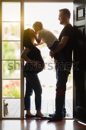 Mixed Race Pregnant Couple Kissing in Doorway. Stock photo © feverpitch