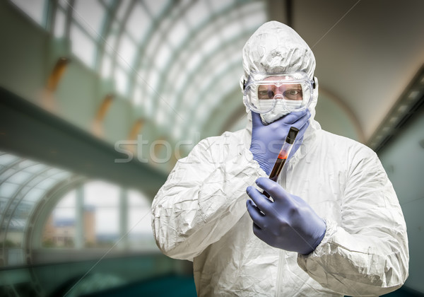 Man Wearing HAZMAT Protective Clothing Holding Test Tube Filled  Stock photo © feverpitch