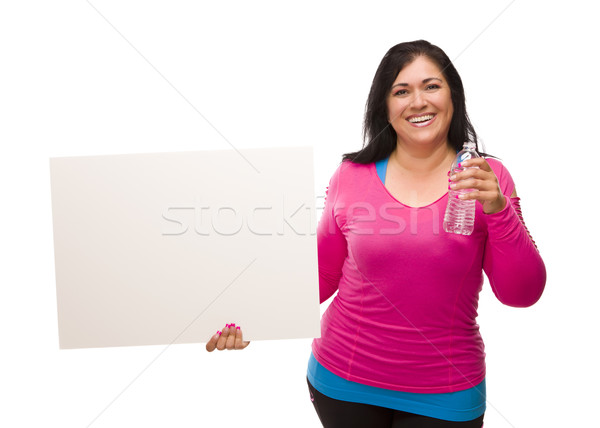 Stock photo:  Hispanic Woman In Workout Clothes with Water and Blank Sign