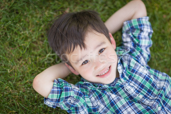 Mixed Race Chinese And Caucasian Young Boy Relaxing On His Back