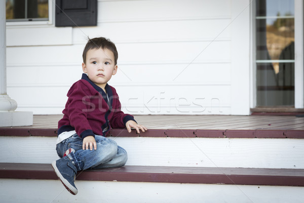 Melancholy Mixed Race Boy Sitting on Front Porch Steps Stock photo © feverpitch