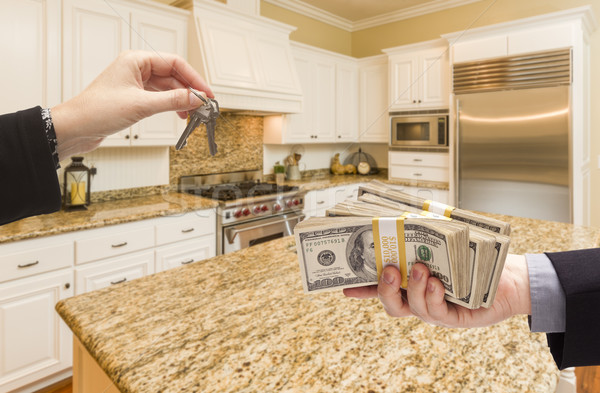 Stock photo: Handing Over Cash for Keys Inside Beautiful Kitchen