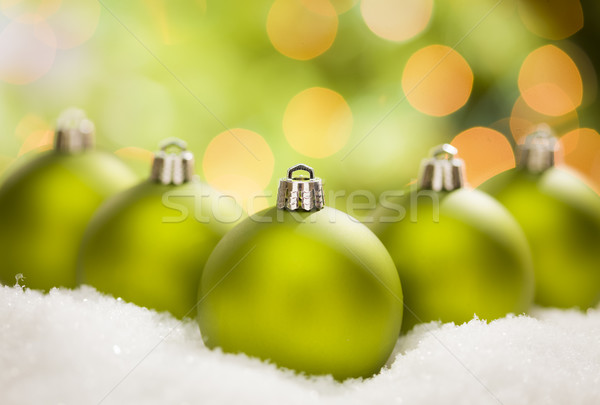 Green Christmas Ornaments on Snow Over an Abstract Background Stock photo © feverpitch