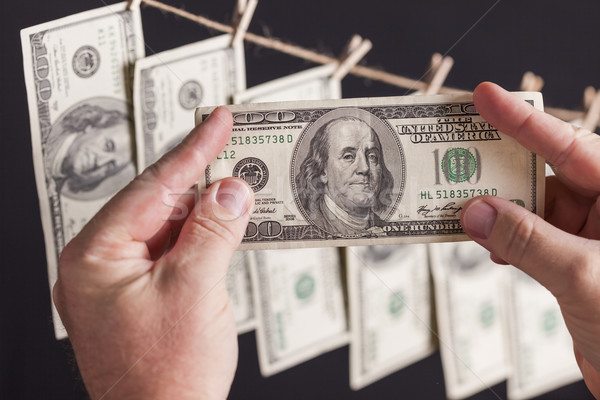 Male Holding Hundred Dollar Bills, Many Handing from Clothesline Stock photo © feverpitch