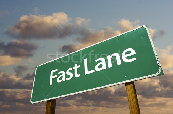 Stock photo: Fast Lane Green Road Sign Over Clouds