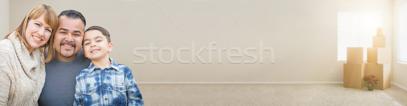 Mixed Race Family In Empty Room With Moving Boxes Banner. Stock photo © feverpitch