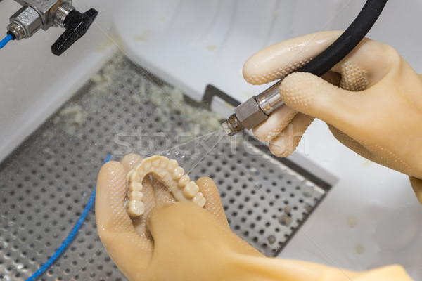 Dental Technician Cleans 3D Printed Dental Implant Bridge Stock photo © feverpitch