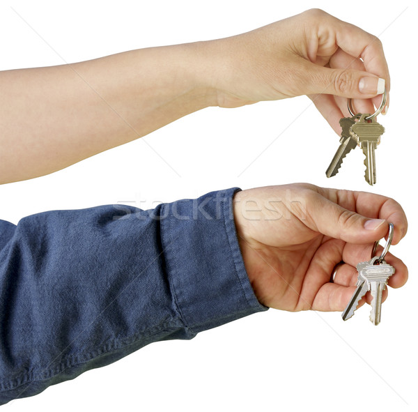 Man and Woman handing over house keys on a white background. Stock photo © feverpitch