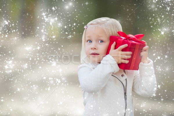 Stock photo: Baby Girl Holding Red Christmas Gift Outdoors with Snow Effect