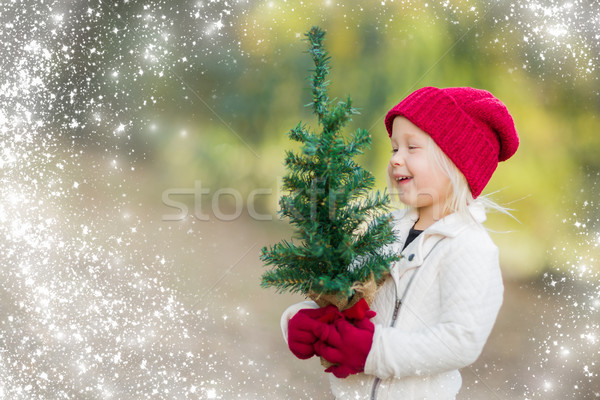 Stock photo: Baby Girl In Mittens Holding Small Christmas Tree with Snow Effe