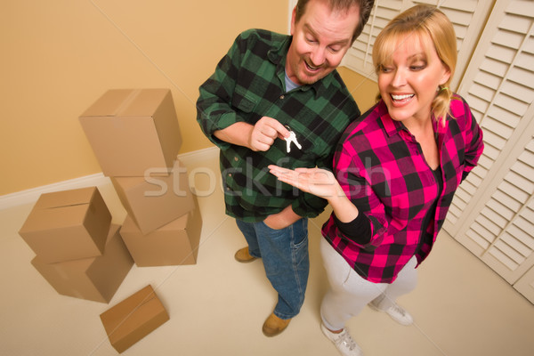 Goofy Excited Man Handing Keys to Smiling Wife Stock photo © feverpitch