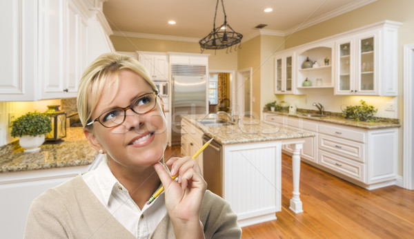 Daydreaming Woman with Pencil Inside Beautiful Custom Kitchen Stock photo © feverpitch