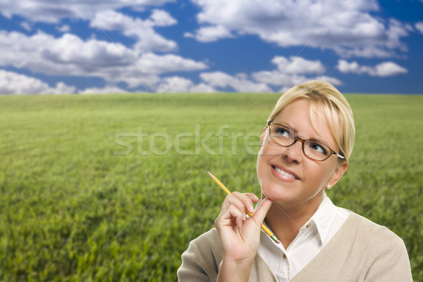 Contemplative Woman in Grass Field Looking Up and Over Stock photo © feverpitch