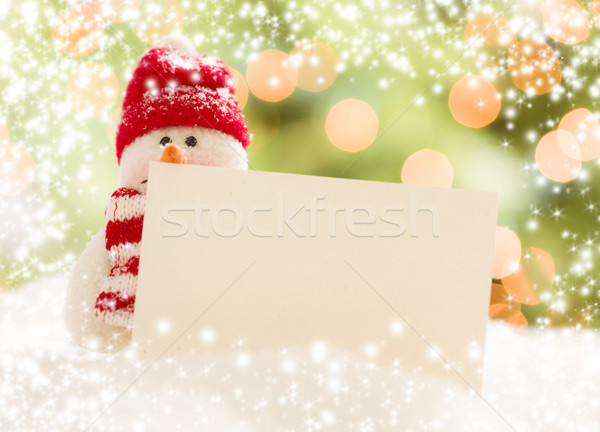 Stock photo: Snowman with Blank White Card Over Abstract Snow and LIght
