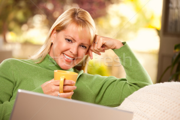 Stock fotó: Gyönyörű · nő · meleg · ital · laptop · gyönyörű · mosolygó · nő