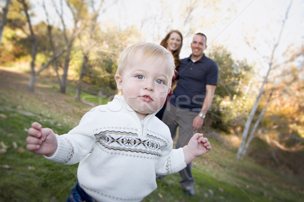 Cute Young Boy Walking as Parents Look On From Behind Stock photo © feverpitch