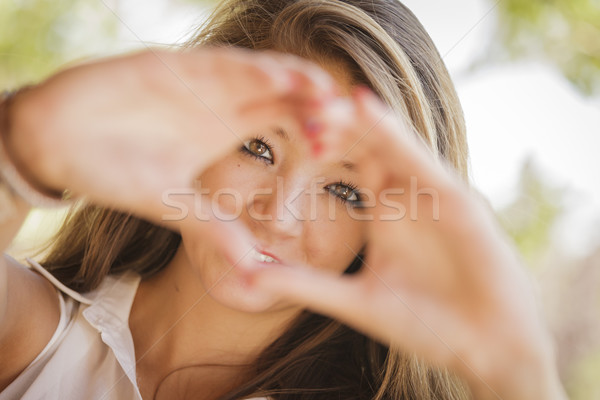 Attractive Smiling Mixed Race Girl Portrait with Heart Hand Sign Stock photo © feverpitch