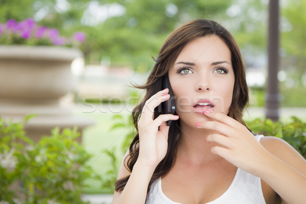 Stock photo: Stunned Young Adult Female Talking on Cell Phone Outdoors