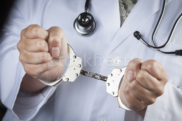 Doctor or Nurse In Handcuffs Wearing Lab Coat and Stethoscope Stock photo © feverpitch