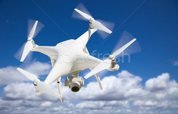 Unmanned Aircraft System (UAV) Quadcopter Drone In The Air. Stock photo © feverpitch