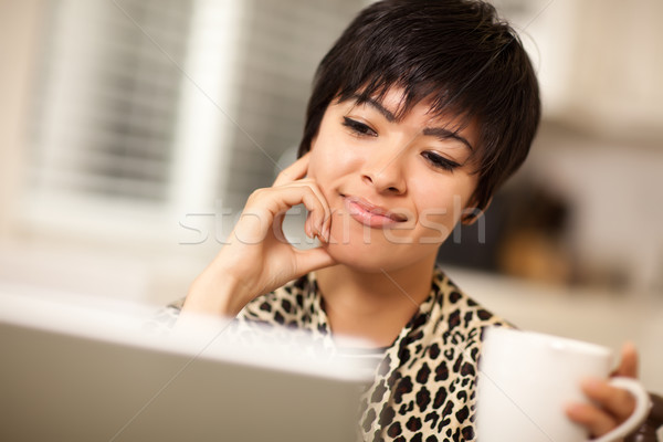 Pretty Smiling Mixed Race Woman Using Laptop Stock photo © feverpitch