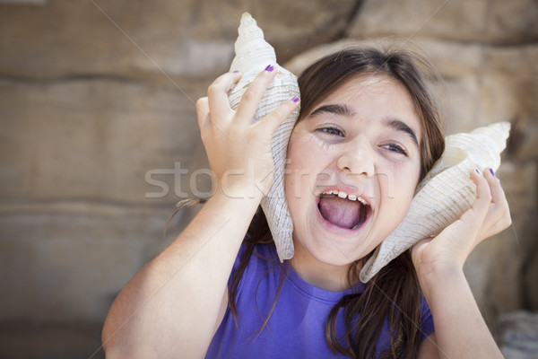 [[stock_photo]]: Jeune · fille · jouer · mer · obus · oreilles