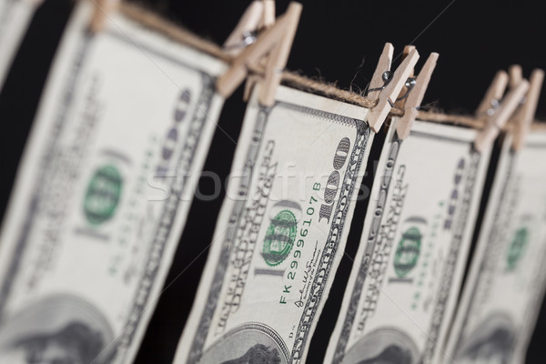 Hundred Dollar Bills Hanging From Clothesline on Dark Background Stock photo © feverpitch