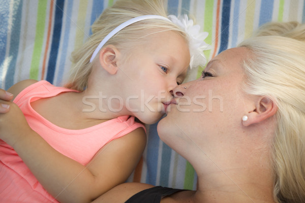 Little Girl Laying on Blanket Kisses Her Mommy Stock photo © feverpitch