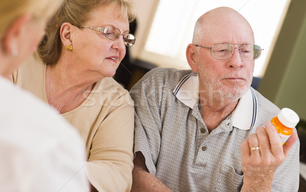 Stock photo: Doctor or Nurse Explaining Prescription Medicine to Senior Coupl