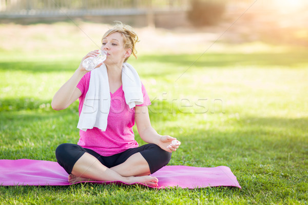 Young Fit Adult Woman Outdoors On Her Yoga Mat with Towel Drinki Stock photo © feverpitch