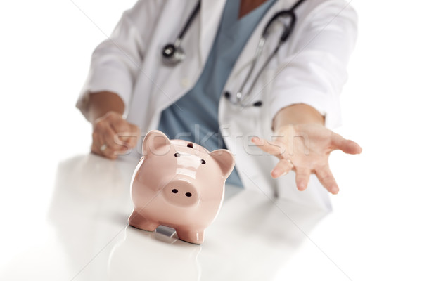 Demanding Doctor Reaches Palm Out Behind Piggy Bank Stock photo © feverpitch